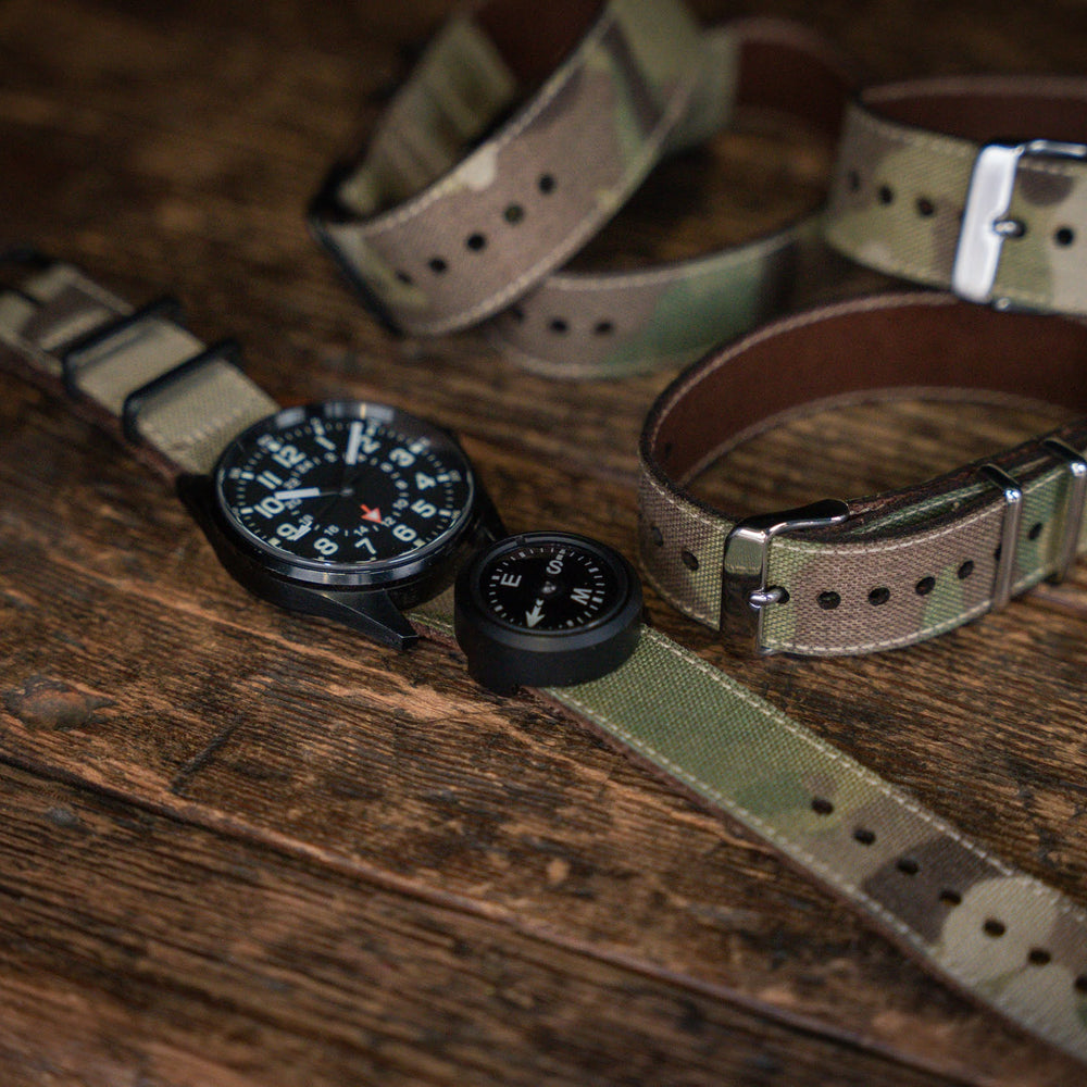 
                  
                    Watches with camouflage straps on a wooden surface
                  
                