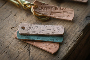 https://craftandlore.com/cdn/shop/products/brass-key-hook-keychain-selvedge-denim-leather-quality-durable-rugged-heritage-classic-rustic-style-keys_2_of_6_300x.jpg?v=1632371925