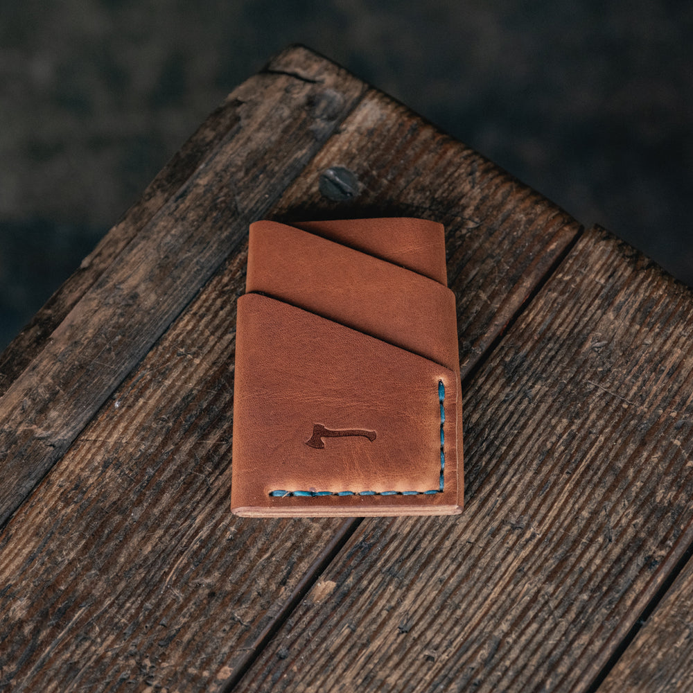 
                  
                    Port Wallet Craft and Lore, Horween Dublin English Tan and hand stitched with turquoise blue thread
                  
                